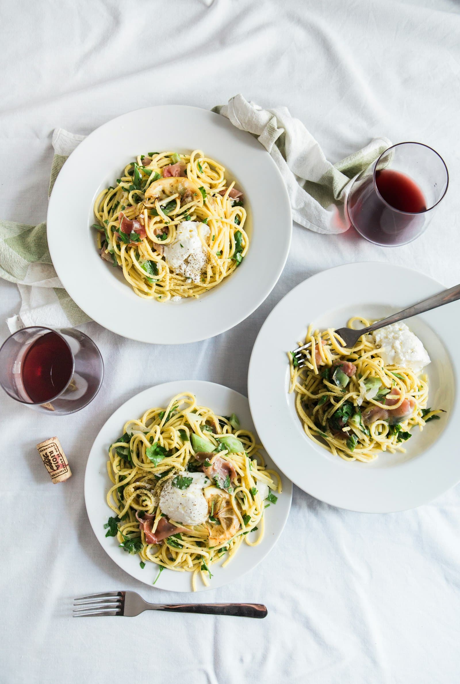 Tre tallerkner pasta med prosciutto og burrata på hvit duk. Hverdagsmiddag for tre, slik den faktisk ser ut.